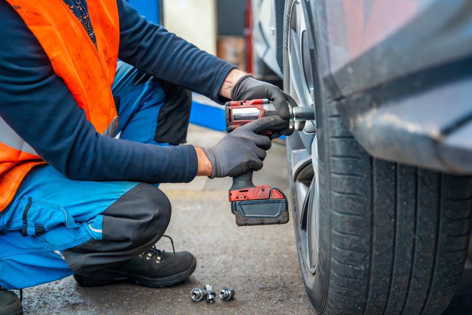 Mobile tire service mechanic working on a car wheel